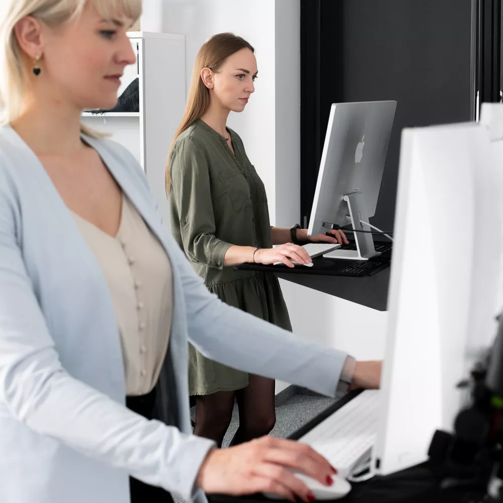 Dwie kobiety pracujące przy komputerach w studiu fotograficznym Orbitvu